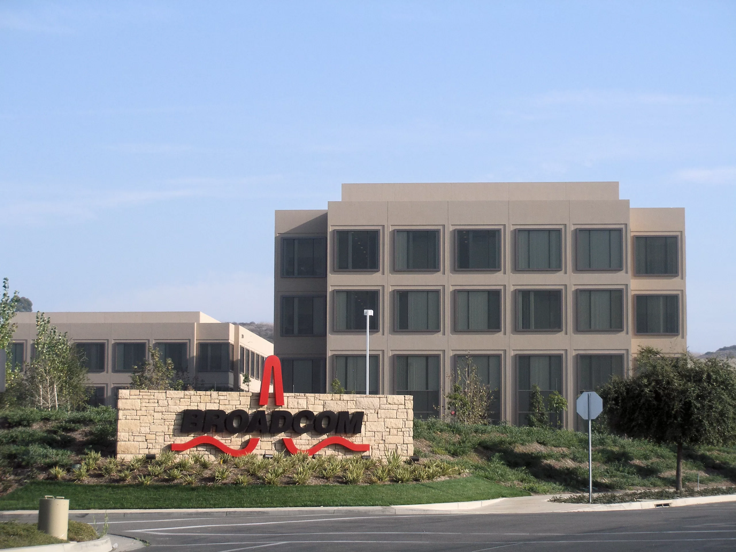 Broadcom logo overlaid on a background of computer chips and circuit boards, symbolizing the company's position in the semiconductor industry and its focus on AI-driven solutions.