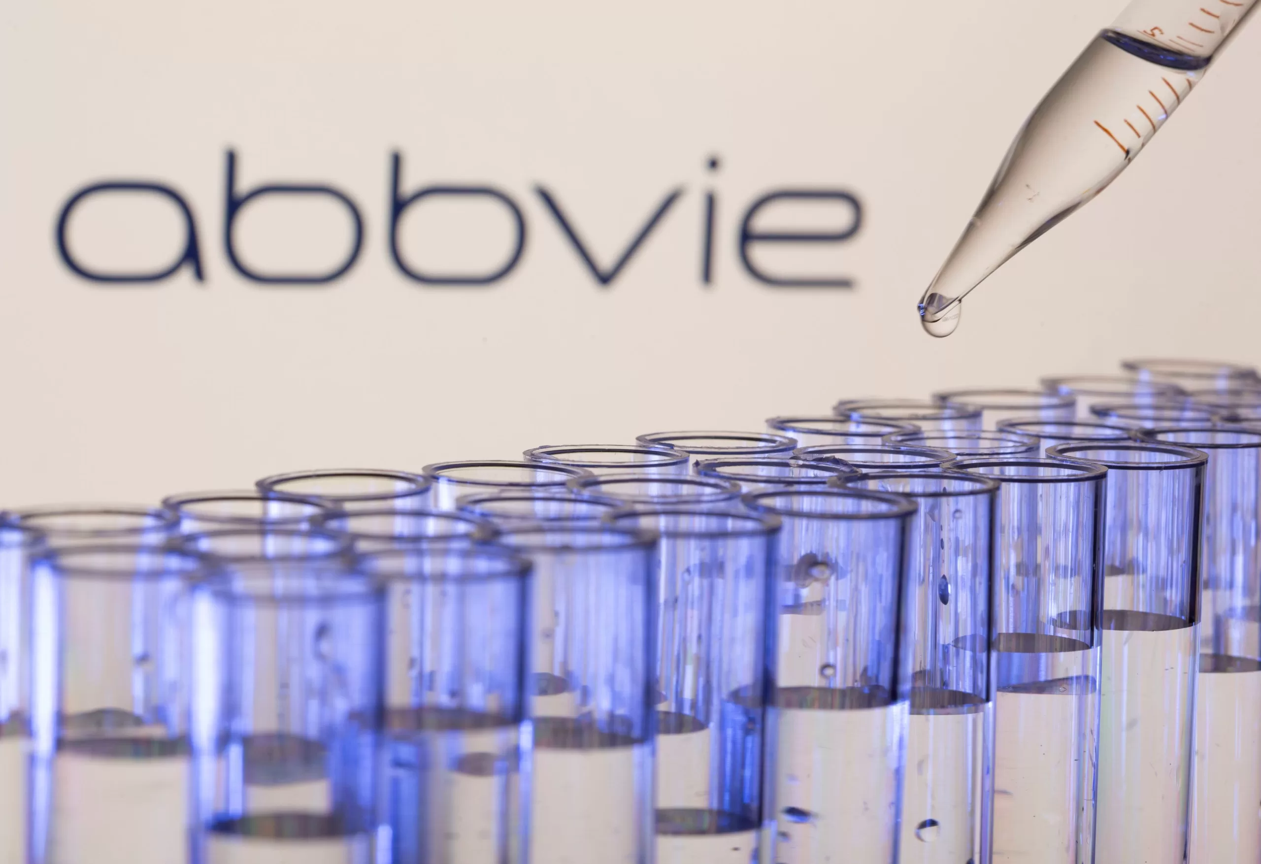 Abbvie researcher holding up a vial of upadacitinib (RINVOQ®) in a laboratory, symbolizing medical innovation and research progress.